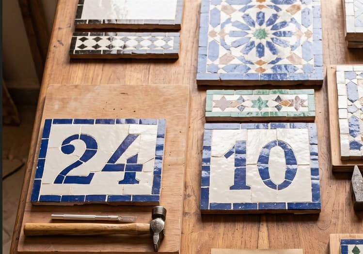 Deux plaques de numéro de maison en zellige sur mesure affichant 24 et 10 en bleu de Fès sur blanc.